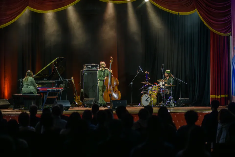 Lima O Trio em apresentação no palco de um teatro.