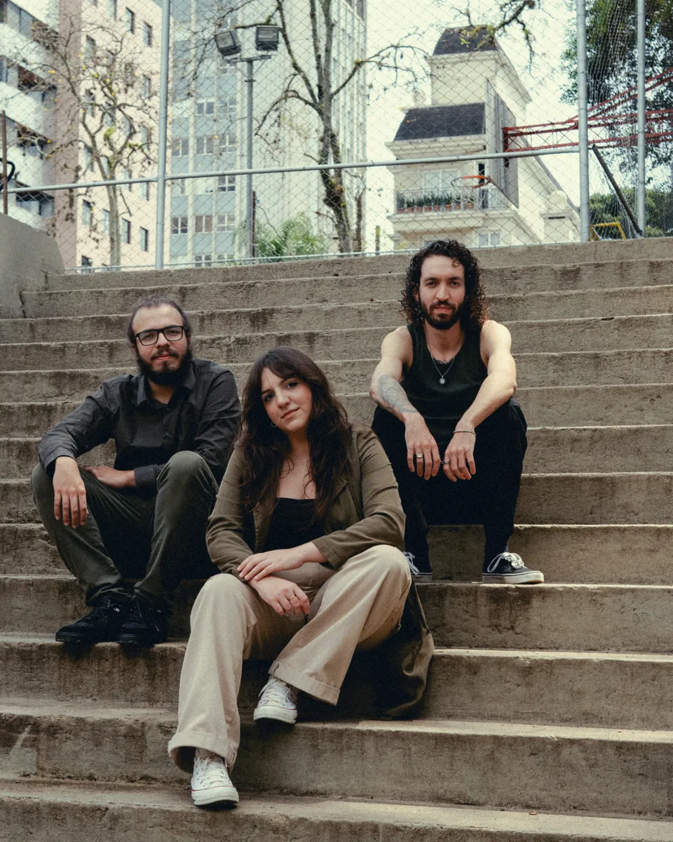 Lima O Trio sentado em uma escadaria.